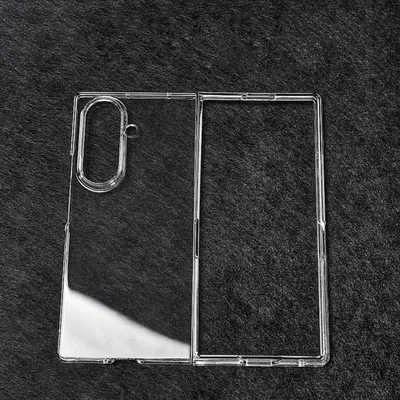 A clear plastic phone case for a foldable phone is laid out on a dark, textured surface.