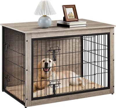 A dog is inside a wooden dog crate with a blanket.