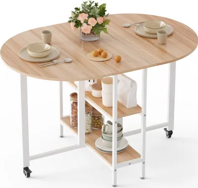 A folding dining table with shelves and wheels, set up and styled with dishes and a floral arrangement.