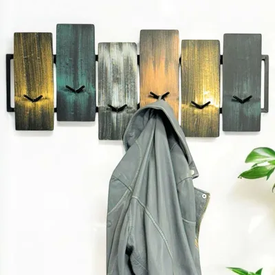 A coat rack with a jacket hanging on it, mounted on a white wall.