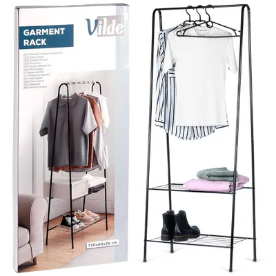 A product shot of a black metal garment rack with clothes and shoes on it, next to a box with product information.