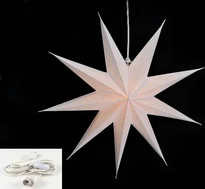 A white paper star lantern with nine points, suspended against a black background. A white power cord with a plug and socket is shown in the bottom left corner.