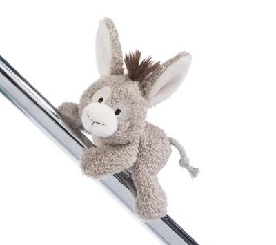 A plush toy donkey is clinging to a metal pole against a white background.