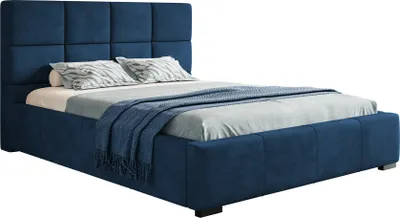 A blue upholstered bed with a headboard and bedding.