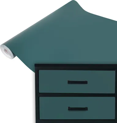 A roll of teal matte vinyl wrap is shown unfurling over a black dresser with two teal drawers.