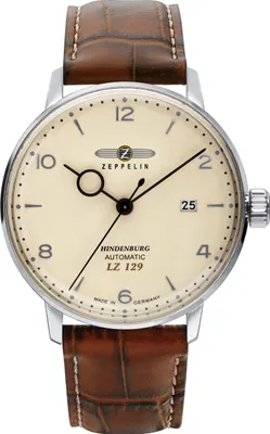 A close-up studio shot of a men's wristwatch with a cream-colored dial and a brown leather strap.