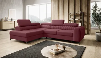 A modern living room with a sectional sofa, coffee table, and shelving unit.