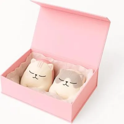 A pink gift box with two cat-shaped bath bombs inside.