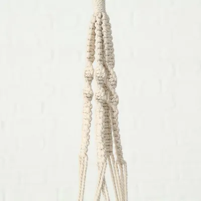 A close-up view of a macrame plant hanger with decorative knots.