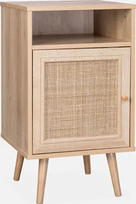 A wooden nightstand with a rattan woven door and a shelf above, standing on four tapered legs.