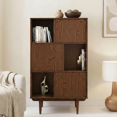 A wooden highboard with shelves and doors, styled in a living room setting with a sofa and a lamp.