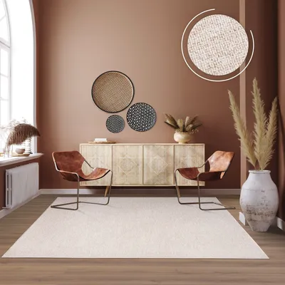 A living room scene featuring a rug, chairs, and a sideboard.