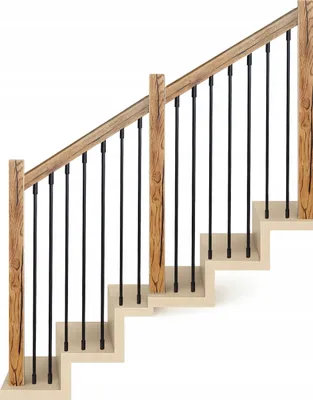A section of a staircase with a wooden handrail and black metal balusters.