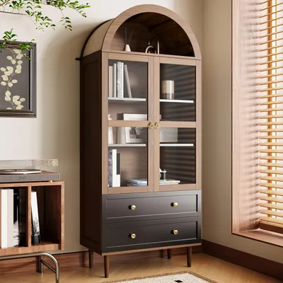 A wooden cabinet with glass doors and drawers, placed next to a window with blinds.
