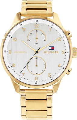 A close-up studio shot of a gold Tommy Hilfiger watch with a white face.