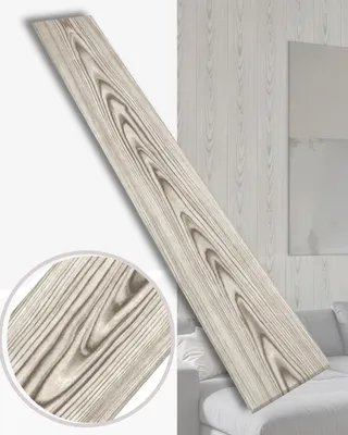 A single plank of wood-effect paneling is shown diagonally against a background of similar paneling and a hint of a sofa.