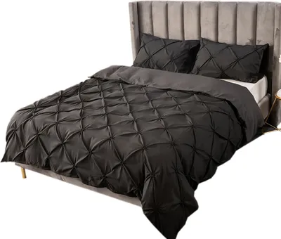 A bed with black bedding and a gray headboard, set against a white background.