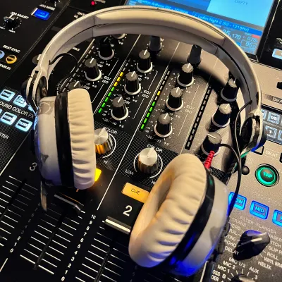 A close-up view of a DJ mixer with headphones resting on it.