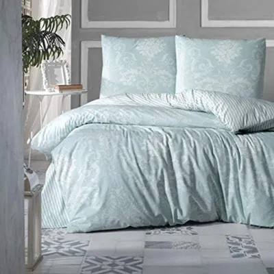 A neatly made bed with light blue bedding and pillows.