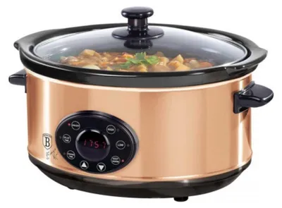 A rose gold slow cooker filled with food, shown from the front.
