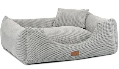 A dog bed with raised sides and a small pillow.