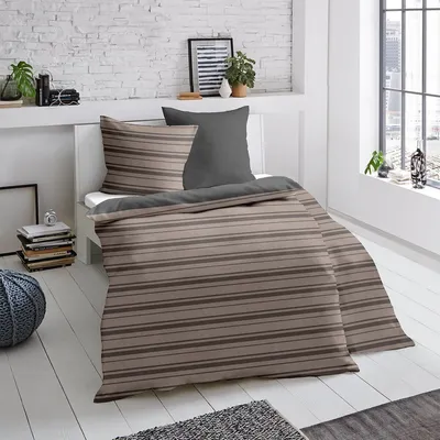 A neatly made bed with striped bedding in a bedroom setting.