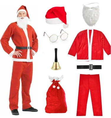 A man dressed as Santa Claus stands next to various components of a Santa costume laid out separately.