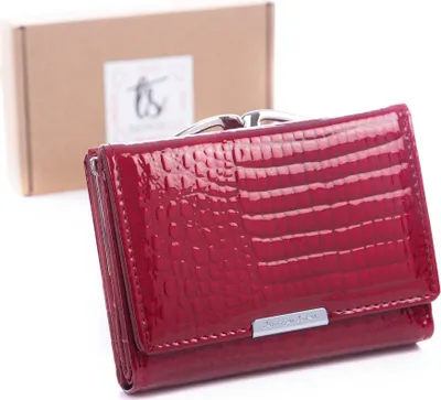 A red leather wallet is shown in front of a cardboard box.