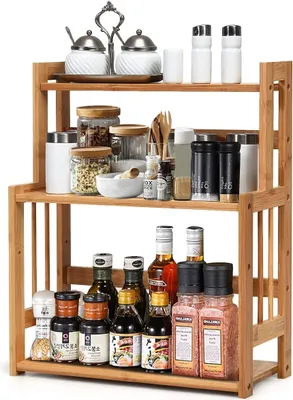 A three-tier bamboo spice rack filled with various spice jars, bottles, and containers.