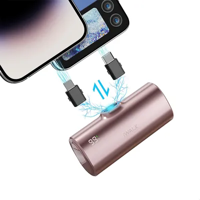 A rose gold portable charger is shown connected to two smartphones via USB-C cables. The charger has a digital display showing '99'.