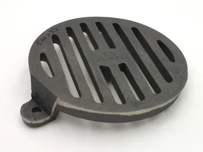 A cast iron grate on a white background.