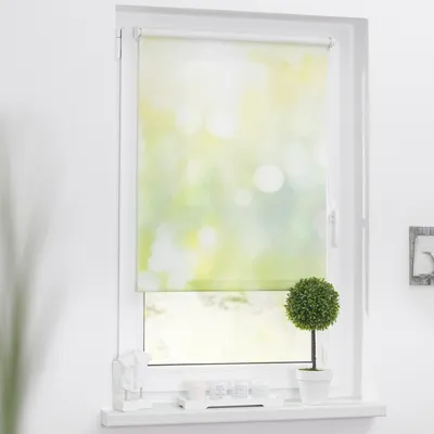 A roller blind with a green and yellow bokeh pattern is shown in a window.