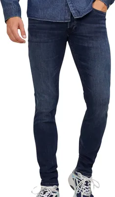 A person wearing blue jeans and a denim shirt, standing against a white background.