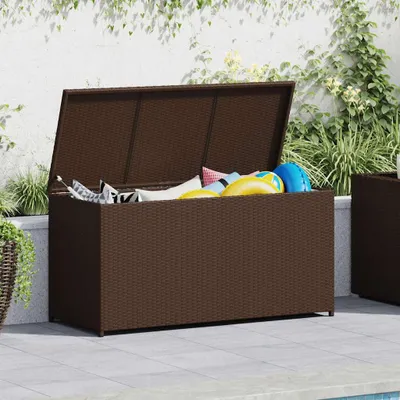 An outdoor storage box filled with colorful cushions and pool toys, placed on a patio next to a swimming pool.