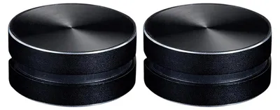Two black, round, portable speakers are shown side-by-side against a white background.