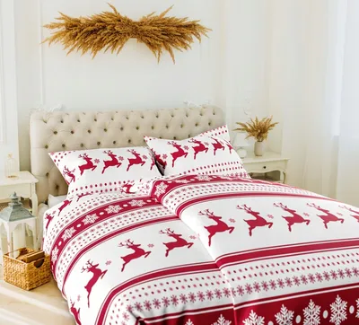 A Christmas-themed duvet cover and pillowcases with a reindeer pattern are displayed on a bed.