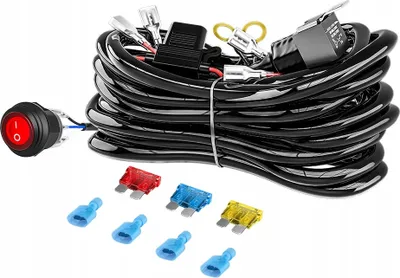 A wiring harness kit for automotive lights, including a switch, relay, fuses, and connectors, laid out on a white background.