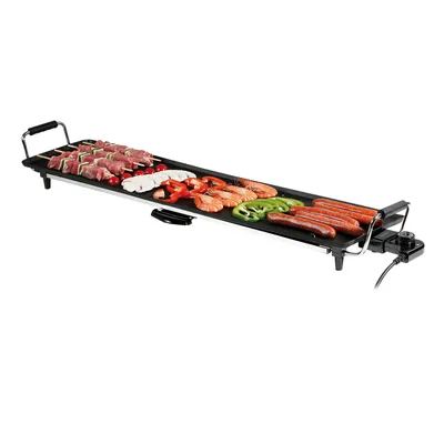 A long, flat electric teppanyaki grill with various foods being cooked on it.