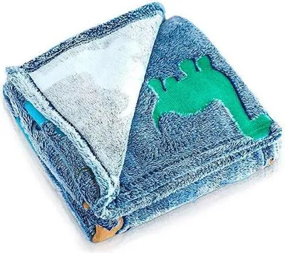 A folded blue blanket with a green dinosaur applique is shown against a white background.