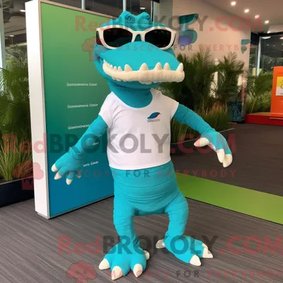 Produktbild von Maskottchen REDBROKOLY eines türkisfarbenen Krokodils mit Laufshorts und Sonnenbrille