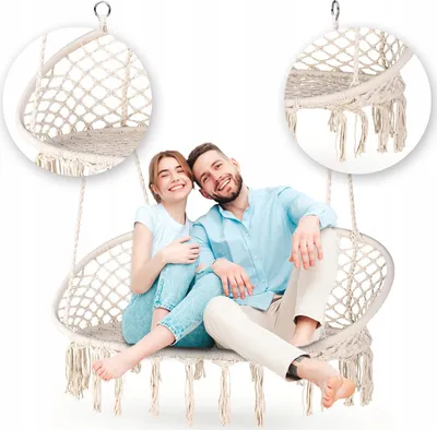A couple sitting in a hanging chair.