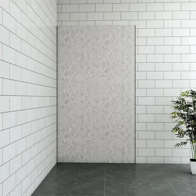 A corner of a room with tiled walls and floor, featuring a large textured panel and a potted plant.