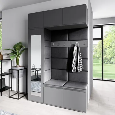 A modern hallway storage unit with a built-in bench, mirror, and coat hooks, next to a window with a view of greenery.