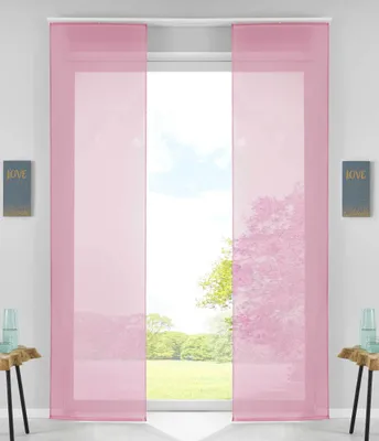 Two pink panel curtains hanging in a window, with a view of trees and sky outside.