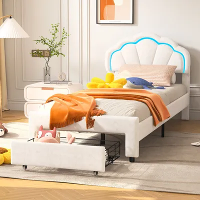 A child's bed in a bedroom setting, with stuffed animals and blankets.
