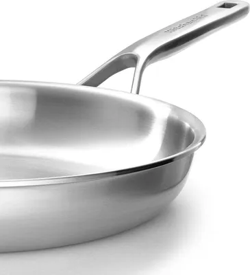 A close-up, studio shot of a stainless steel frying pan.