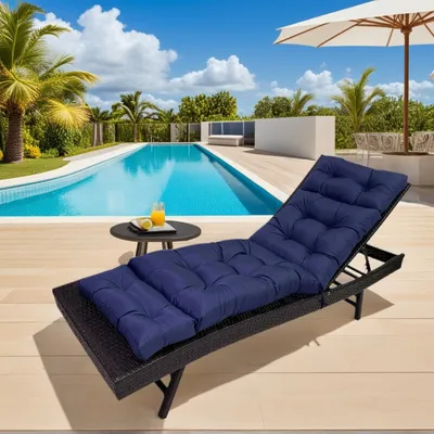 A navy blue chaise lounge cushion is placed on a black chaise lounge next to a swimming pool.