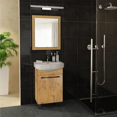 A bathroom vanity with a sink and mirror, next to a shower stall.