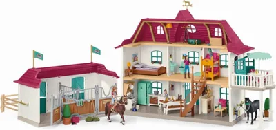 A toy horse stable and house playset with figures and horses.