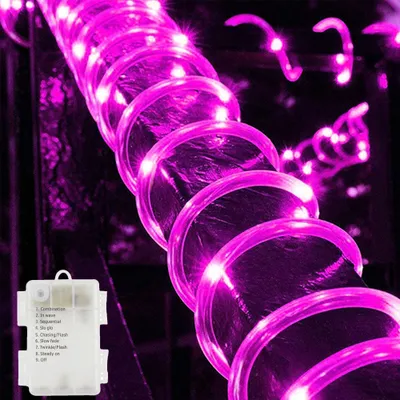 A close-up of a pink LED rope light coiled around a dark object, with a battery pack visible in the lower left corner.